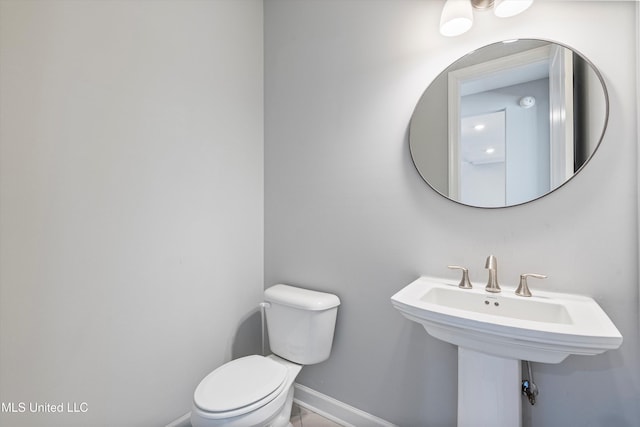 bathroom with toilet and baseboards