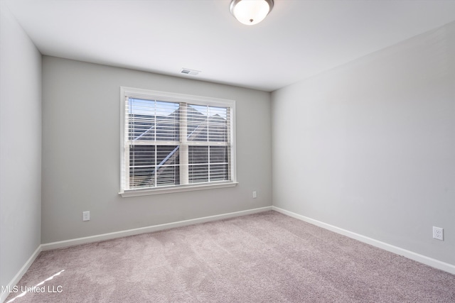 empty room featuring carpet floors and baseboards