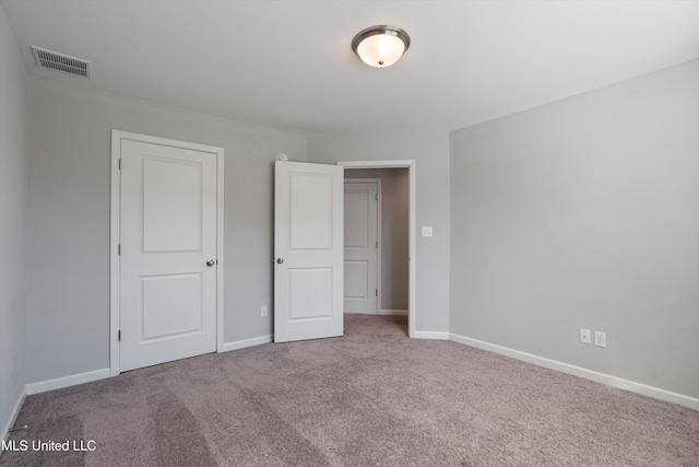 unfurnished bedroom featuring carpet, visible vents, and baseboards