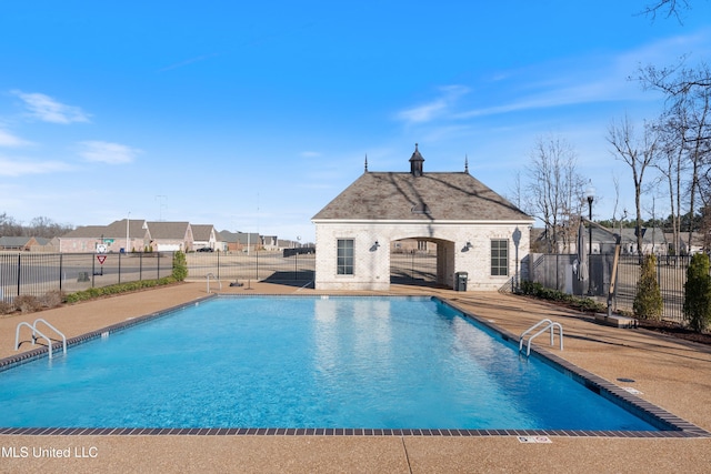 pool with fence, an outdoor structure, an exterior structure, and a patio