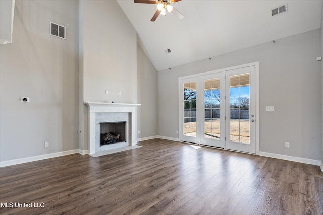 unfurnished living room with dark wood-style floors, a high end fireplace, visible vents, and baseboards