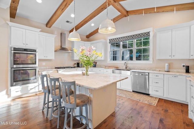 1075 S Laughter Rd, Hernando, MS 38632 - kitchen featuring stainless steel appliances, wall chimney exhaust hood, a warming drawer, light wood-style floors, and a kitchen island