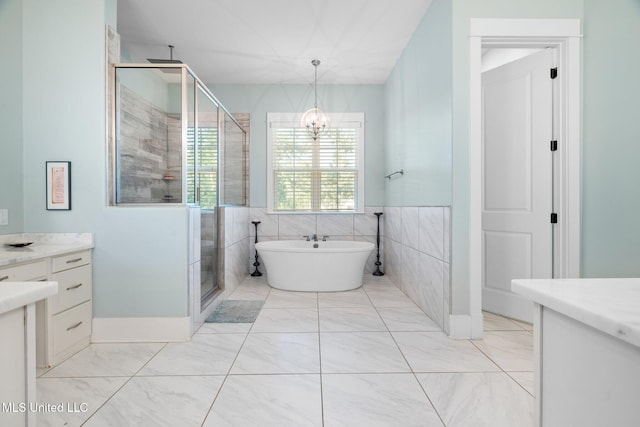1075 S Laughter Rd, Hernando, MS 38632 - full bathroom featuring vanity, a stall shower, a freestanding bath, marble look tiles, and tile walls
