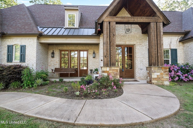 1075 S Laughter Rd, Hernando, MS 38632 - property entrance featuring brick siding, french doors, a porch, a standing seam roof, and roof with shingles