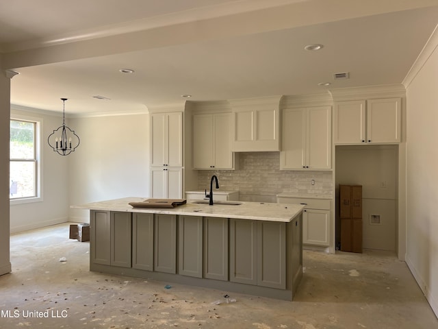 609 Cobalt Way, Brandon, MS 39042 - kitchen featuring tasteful backsplash, white cabinetry, a kitchen island with sink, a chandelier, and ornamental molding