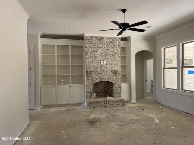 609 Cobalt Way, Brandon, MS 39042 - unfurnished living room with arched walkways, built in shelves, ornamental molding, a ceiling fan, and a brick fireplace