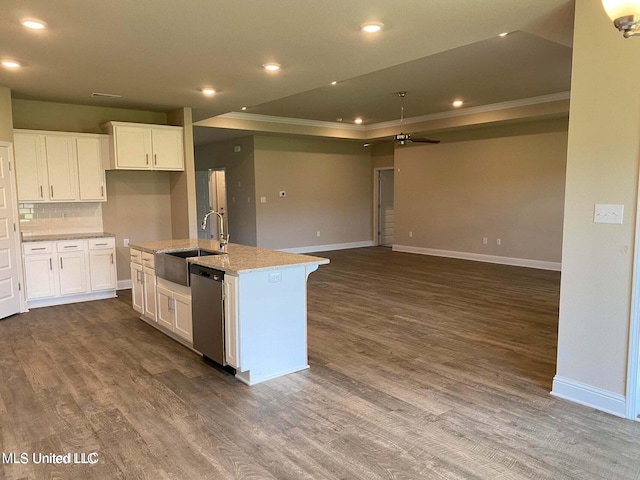 kitchen with light stone countertops, sink, white cabinetry, stainless steel dishwasher, and a kitchen island with sink