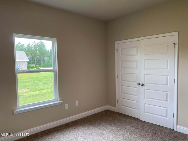 unfurnished bedroom featuring multiple windows, a closet, and carpet