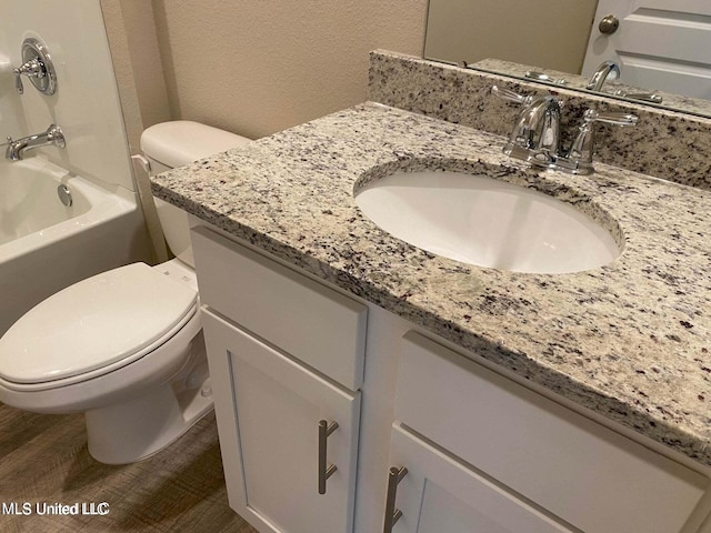 full bathroom featuring vanity, toilet, hardwood / wood-style flooring, and shower / bathing tub combination