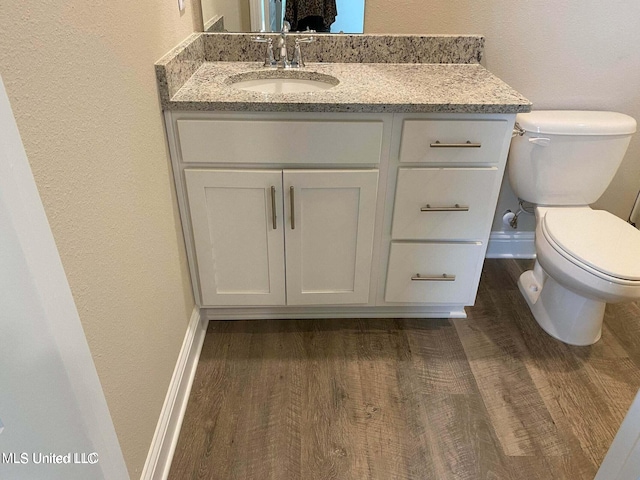 bathroom with vanity, toilet, and wood-type flooring