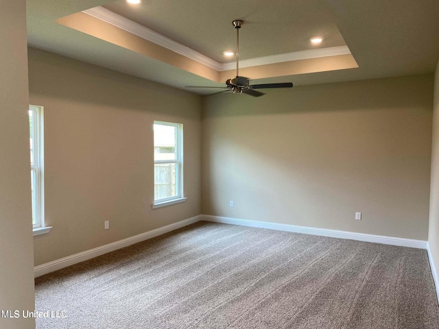 unfurnished room featuring carpet, ceiling fan, crown molding, and a raised ceiling