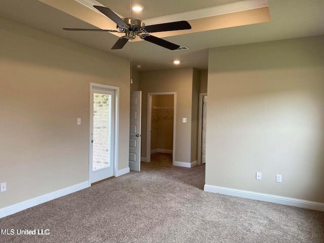 unfurnished bedroom featuring a spacious closet, ceiling fan, a closet, and light colored carpet