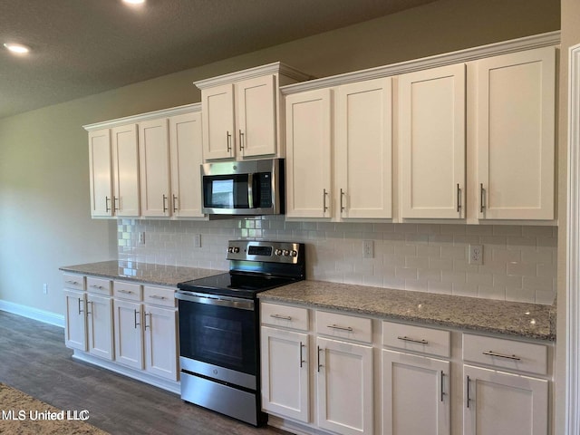 kitchen with dark hardwood / wood-style floors, stainless steel appliances, light stone countertops, white cabinets, and tasteful backsplash