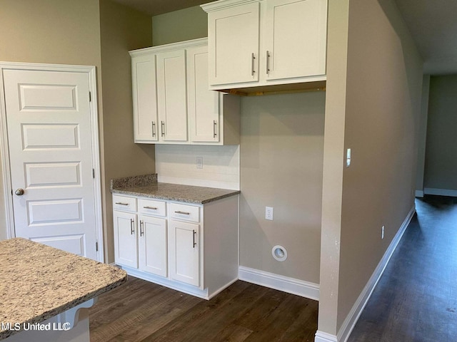 kitchen featuring light stone counters, backsplash, dark hardwood / wood-style floors, and white cabinets