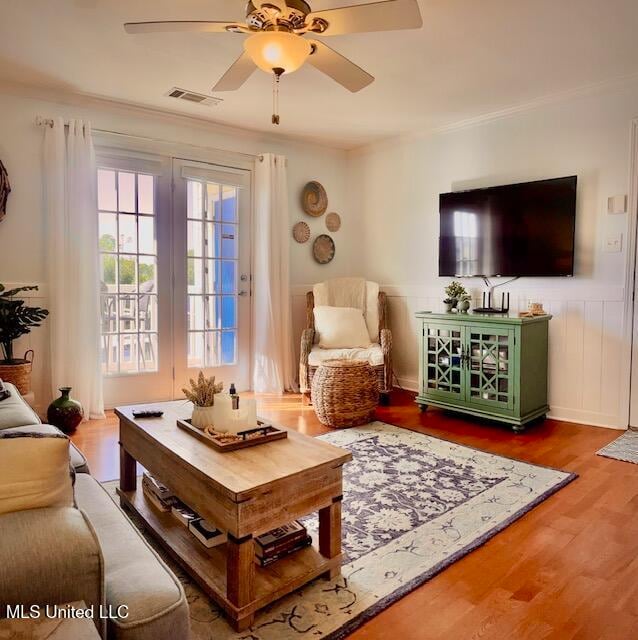 living room featuring ceiling fan, crown molding, and wood-type flooring