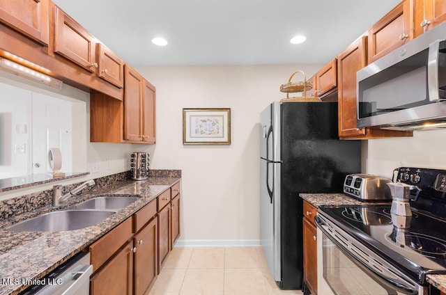 2421 Beachview Dr Unit B02, Ocean Springs, MS 39564 - kitchen with brown cabinetry, a sink, dark stone countertops, and stainless steel appliances