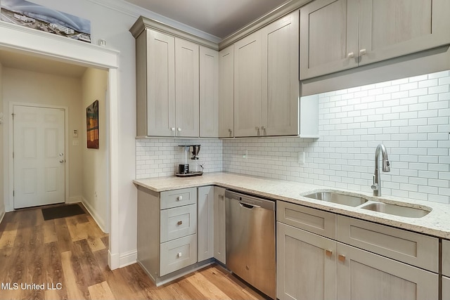 kitchen featuring sink, light stone counters, light hardwood / wood-style floors, decorative backsplash, and stainless steel dishwasher