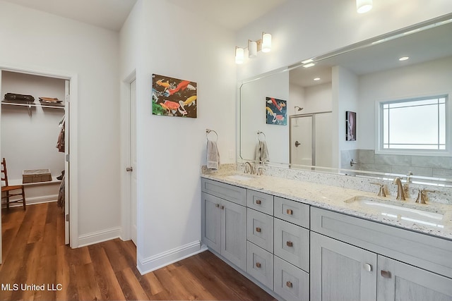 bathroom featuring hardwood / wood-style flooring, vanity, and walk in shower