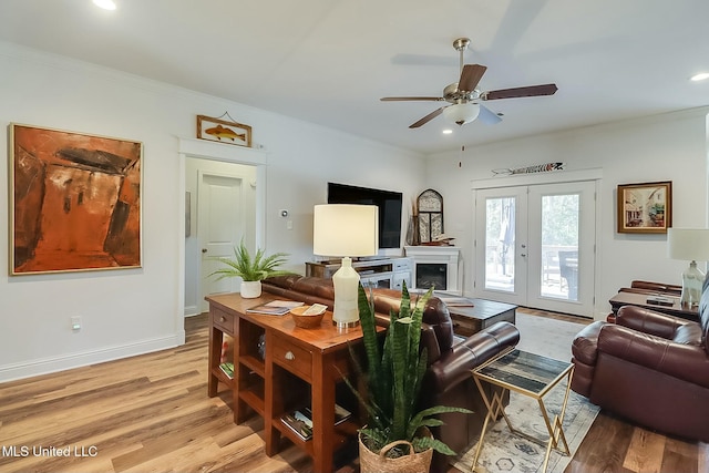 living room with crown molding, light hardwood / wood-style flooring, and french doors