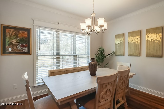 dining area with dark hardwood / wood-style flooring, crown molding, and an inviting chandelier