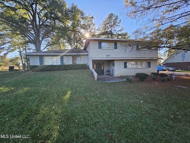 back of property featuring a patio area and a lawn