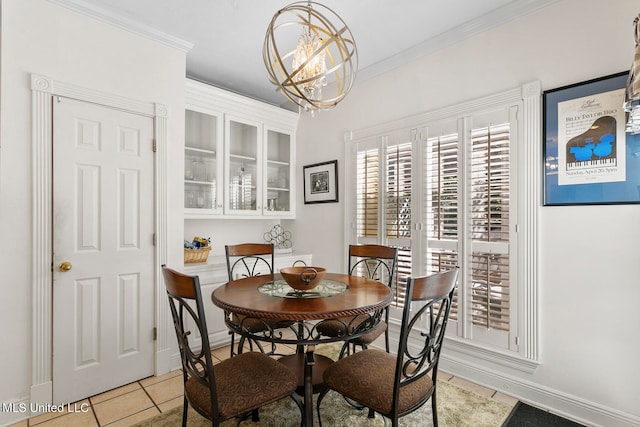 tiled dining space featuring ornamental molding and a chandelier