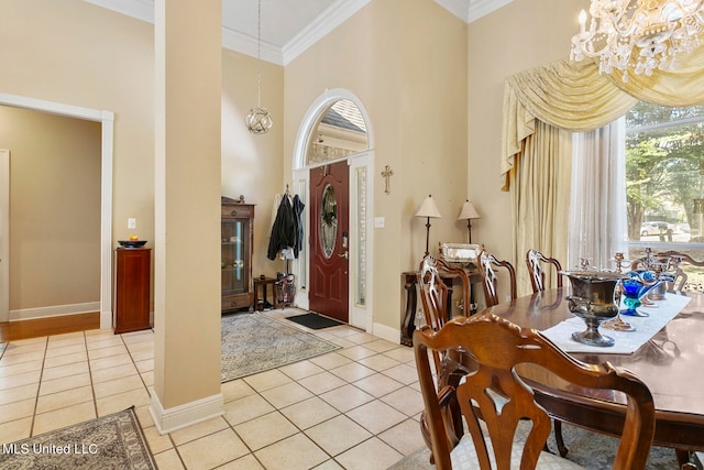 foyer with an inviting chandelier, ornamental molding, light tile patterned flooring, and a high ceiling