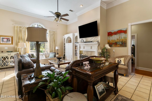 living room with ornamental molding, ceiling fan, a fireplace, and light tile patterned floors