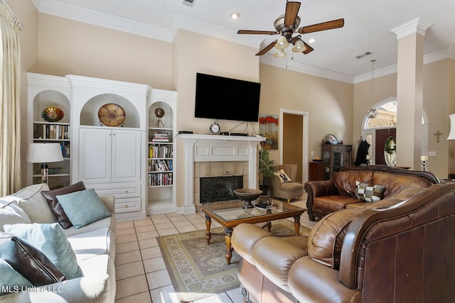 living room featuring ceiling fan, light tile patterned floors, ornamental molding, a high ceiling, and built in shelves