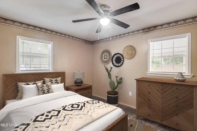 carpeted bedroom with ceiling fan and multiple windows