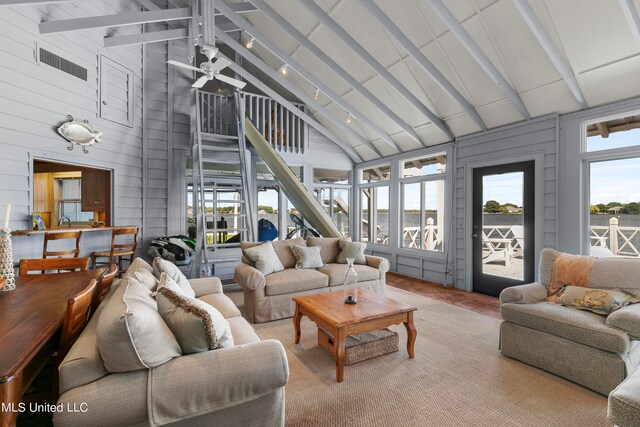 sunroom featuring ceiling fan and vaulted ceiling with beams