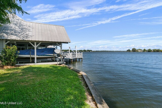 view of dock featuring a lawn and a water view