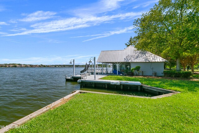 dock area with a yard and a water view