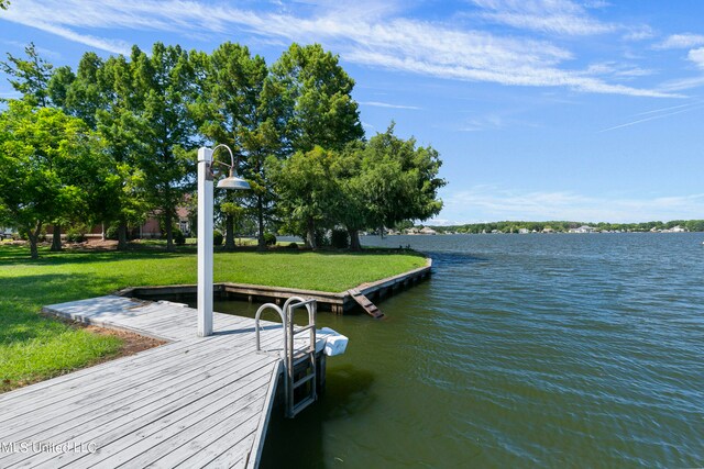 dock area with a water view and a lawn