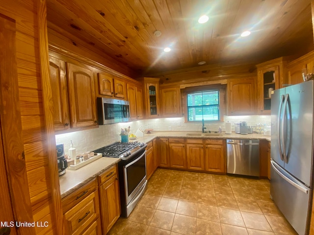 kitchen with appliances with stainless steel finishes, sink, backsplash, wood ceiling, and light tile patterned floors