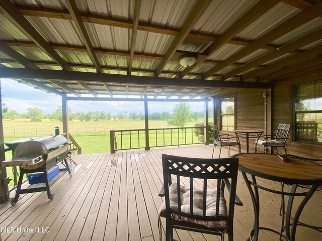 wooden deck featuring a rural view, grilling area, and a lawn