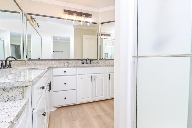 bathroom with vanity, ornamental molding, and wood-type flooring