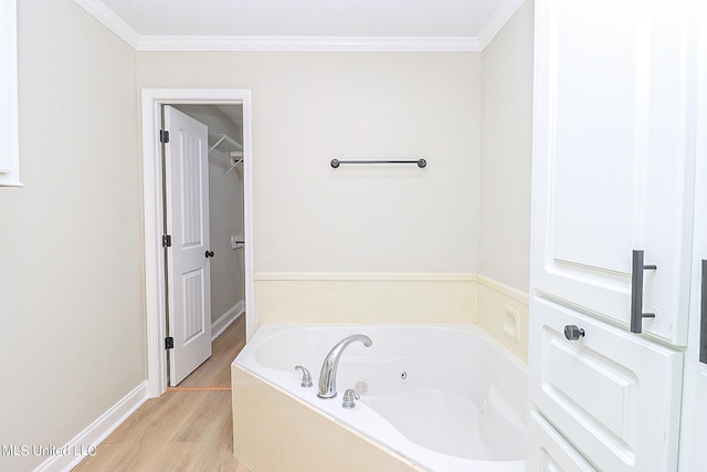 bathroom featuring crown molding, hardwood / wood-style flooring, and a bath