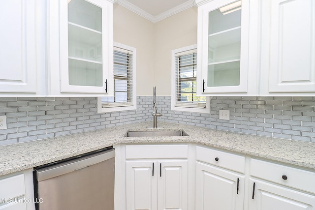 kitchen with ornamental molding, sink, stainless steel dishwasher, and white cabinets