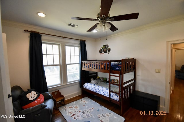 bedroom with ceiling fan, crown molding, and dark wood-type flooring