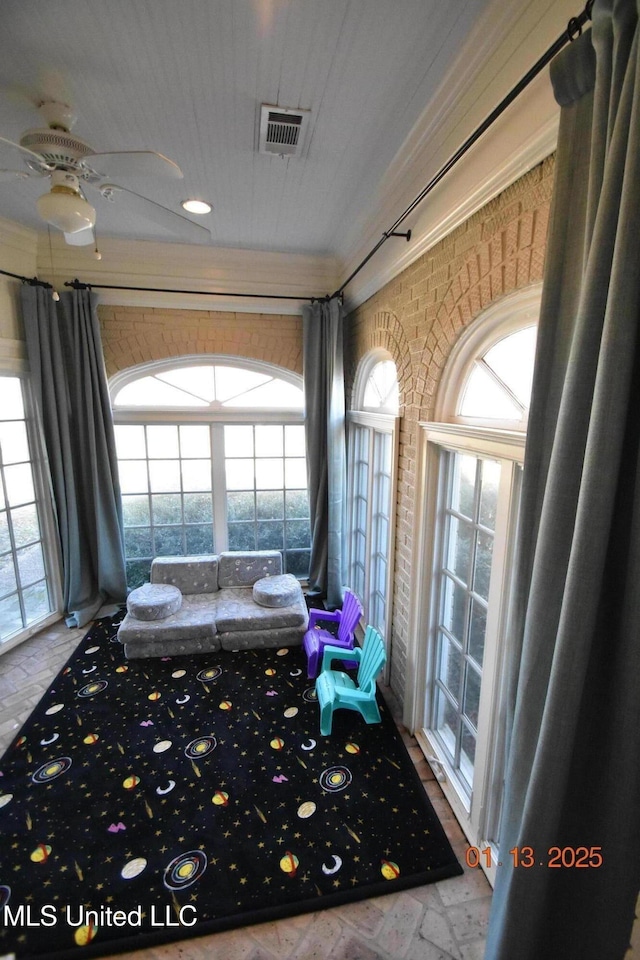 interior space featuring brick wall and ceiling fan