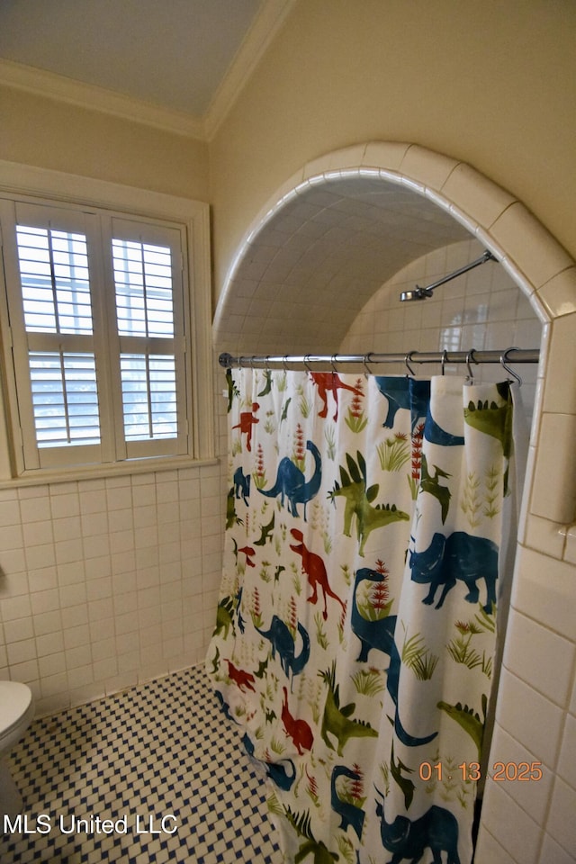 bathroom with toilet, tile patterned flooring, crown molding, and walk in shower