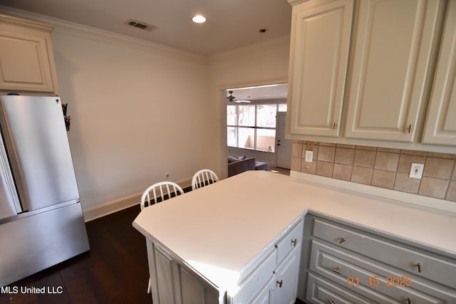 kitchen with crown molding, dark hardwood / wood-style flooring, white cabinets, white refrigerator, and ceiling fan