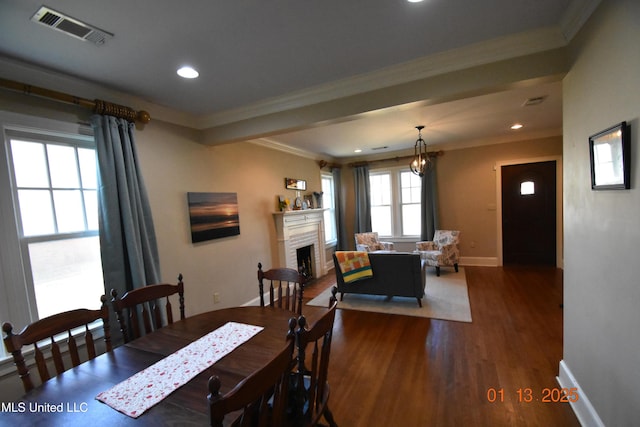 dining space featuring a chandelier, crown molding, and dark hardwood / wood-style floors