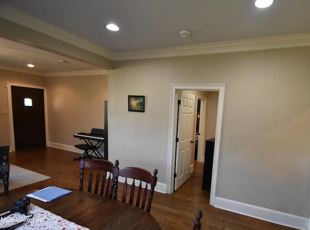 dining area with ornamental molding and dark hardwood / wood-style floors