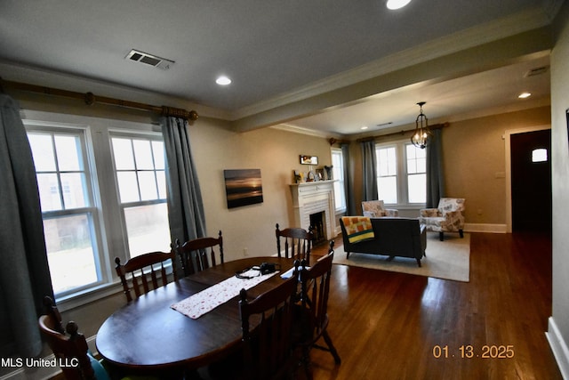 dining space featuring a healthy amount of sunlight, crown molding, and dark hardwood / wood-style flooring