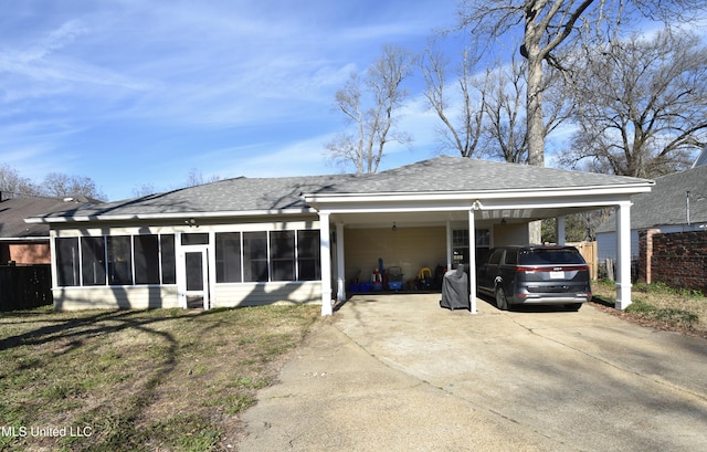 back of property with a yard, a carport, and a sunroom