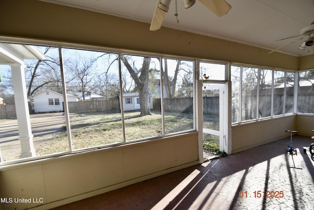 unfurnished sunroom featuring ceiling fan