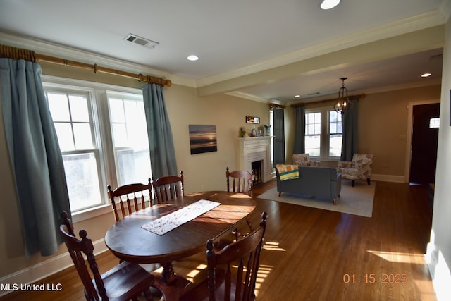 dining area featuring ornamental molding, dark wood-type flooring, and plenty of natural light