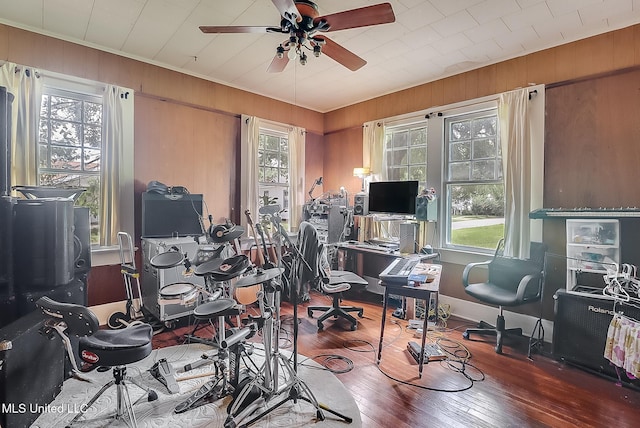 office with wooden walls, a ceiling fan, and hardwood / wood-style floors